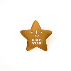 a gold star pin with the words gold star on it