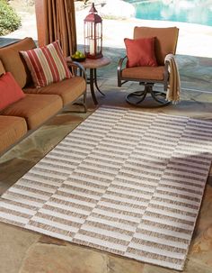 a living room with two chairs and a rug on the floor