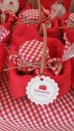 red and white checkered table cloths with apples on them for sale at an outdoor market