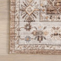 a beige and brown rug on top of a wooden floor