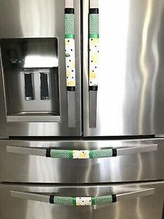 two stainless steel refrigerators with green tags on them