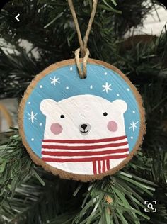 a wooden ornament with a polar bear on it hanging from a christmas tree