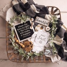 a basket filled with baby items on top of a wooden floor next to a blanket