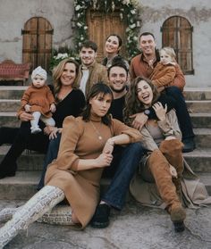 a group of people sitting on the steps in front of a building