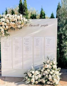 an outdoor seating area with white flowers and greenery