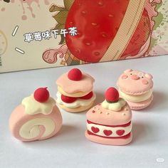 there are some miniature cakes and pastries in front of a box with a strawberry on it