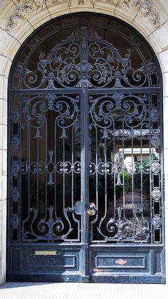 an ornate iron door with two bicycles parked in front