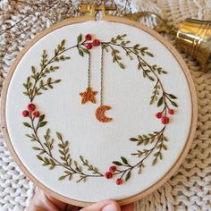 someone is holding up a embroidery hoop with a star and moon on it