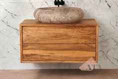 a bathroom vanity with a marble sink and wooden cabinet