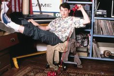 a young man sitting on top of a chair in front of a computer desk