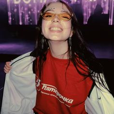 a woman with long hair wearing glasses and a red shirt