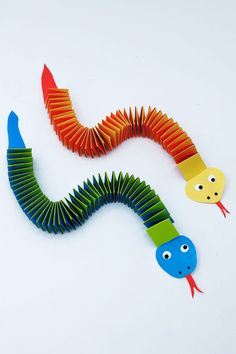 an image of a very colorful paper worm on the white surface with other items around it