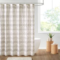 a bathroom with a bathtub, rug and shower curtain in front of the window