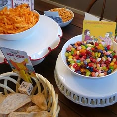 a table topped with bowls filled with different types of candy and crackers on top of plates