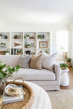 a living room filled with furniture and lots of books on the shelves in front of it