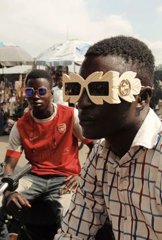 two young men sitting next to each other wearing wooden bow ties and sunglasses on their faces