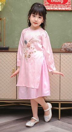 Girl Modern Vietnamese Ao Dai Cach Tan (áo dài bé gai), Kids Vietnamese traditional dress Color: pink with pink skirt Fabric: silk with embellishments Age Wgt(kg/lb) Height(cm/in)Chest (cm/in) 110-12/22-26 80/31.5 51-53/20-20.8 212-14/26-30 90/35 53-55/20.8-21.6 314-16/30-35 98/38.5 54-56/21.3-22 416-18/35-39 104/41 55-57/21.6-22.4 518-21/39-46 110/43 56-58/22-22.8 621-23/46-50 116/45.5 57-59/22.4-23.2 723-26/50-57 122/48 58-62/22.8-24.4 826-29/50-64 128/50 61-65/24-25.5 929-32/64-70 134/52.5 64 Traditional Long Sleeve Dress For Tea Ceremony, Traditional Cheongsam For Spring Festivals, Pink Long Sleeve Cheongsam For Spring, Spring Festive Traditional Cheongsam, Traditional Festive Spring Cheongsam, Traditional Spring Festival Cheongsam, Spring Festival Traditional Cheongsam, Long Fitted Pink Ao Dai, Spring Pink Long Sleeve Cheongsam