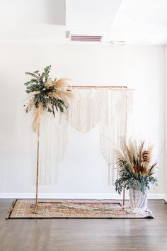 two potted plants sitting on top of a wooden floor next to a white wall