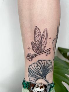 a woman's leg with a tattoo on it and a dragonfly flying over the top