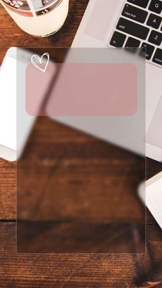 an open laptop computer sitting on top of a wooden desk next to a cup of coffee