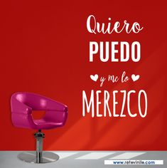 a purple chair sitting in front of a red wall with spanish words on it and a pink chair