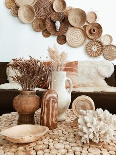 a living room filled with lots of vases and baskets on top of a table