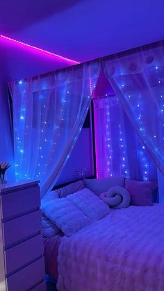 a bedroom decorated in purple and blue lights