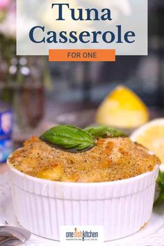 a close up of a casserole on a plate with lemons in the background