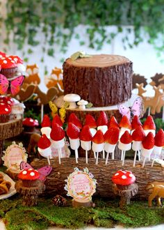 a table topped with lots of cupcakes covered in red and white frosting