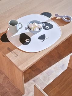 there is a panda bear plate on the table with coffee and marshmallows