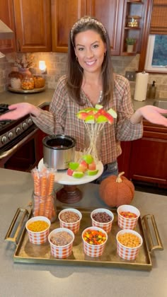 a woman is holding out her hands in front of some food items on a tray