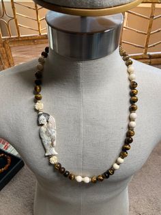 A gorgeous vintage Geisha Bone Tiger Eye Necklace. Spectacular. Circa 1950s. Handcrafted. Made in Japan by Japanese artisans attention to detail. Hand carved, hand strung, hand painted. Unique in that pendant is mounted off center. Guaranteed compliments. A worthy addition to nay collection. Necklace is a slip over measuring 29" in length. Gold bead separators. Magnificent hand carved flowers placed at each end of pendant. Artisan Carved Necklace For Collectors, Artisan Carved Necklace Collectible, Vintage White Hand-strung Jewelry, Vintage Hand Painted Brown Jewelry, Hand Painted Brown Vintage Jewelry, Vintage Brown Hand Painted Jewelry, Brown Hand Painted Vintage Jewelry, Vintage White Hand-strung Necklaces, Vintage Carved Round Beads Necklace