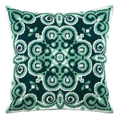 a green and white pillow with an intricate design on the front, sitting on a white surface