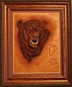 a painting of a bear's head with its mouth open and paw prints on it