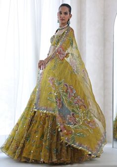 Featuring an exquisite yellow printed lehenga adorned with a fun floral print and highlighted with beautiful embroidery, exuding grace and allure. Paired with an exquisitely embroidered classic blouse and a luxurious printed and embroidered dupatta. This ensemble is ideal for a wedding reception, ensuring you shine with elegance and charm. Composition : Lehenga, Blouse, Dupatta - Organza Care: Dry Clean Only and Vacuum Storage This product can be customized for sleeves, length of blouse and neckline Delivery : 4-6 weeks as the product is hand crafted. Check Size Guide or choose MySize for free customisation (All Sizes above XL can be made at 15% additional cost) For more information and sizes please contact fabiliciousfashion@gmail.com or visit our Copenhagen studio. About the Designer : M Dreamy Lehenga, Mahima Mahajan, Embroidered Embellishments, Heavy Lehenga, Lehenga Style Saree, Print Lehenga, Ghaghra Choli, Indian Bridesmaid Dresses, Yellow Lehenga