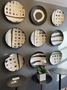 the wall is decorated with black and white plates that are hanging on the gray wall