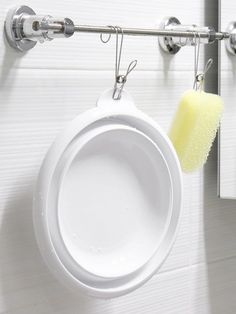 a white cup with a yellow sponge hanging from it