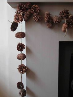 pine cones are hanging on the wall next to a fireplace