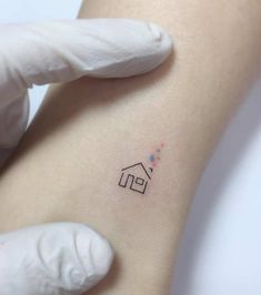 a small house tattoo on the right side of the left arm, with stars coming out of it