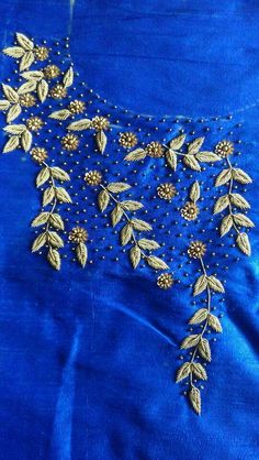 an embroidered blouse with gold leaves and beads