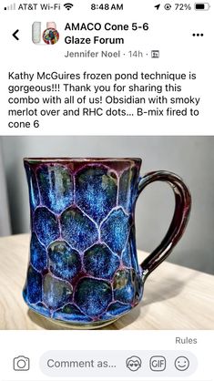 a blue and purple mug sitting on top of a wooden table