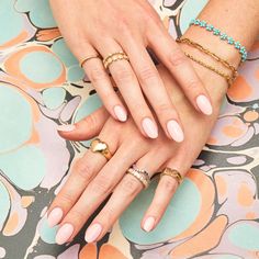 two women's hands holding each other with different rings on their fingers and nails