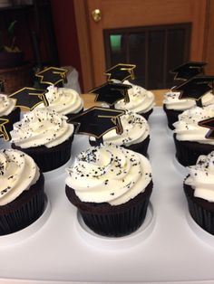 cupcakes with white frosting and graduation decorations