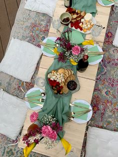 a table set up with food and wine for an outdoor dinner or brunch