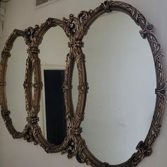 three oval mirrors sitting on top of a wall