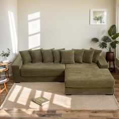 a living room with a large sectional couch in the middle and a book on the floor