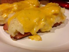 a white plate topped with cheesy potatoes covered in cheese