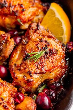 chicken with cranberry sauce and lemon wedges in a skillet, ready to be eaten