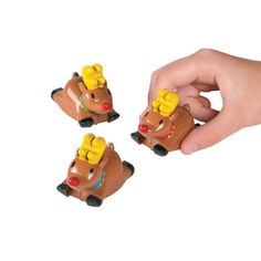 three small toy animals in the shape of bears with bows on their heads are being held by a person's hand