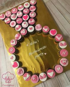 cupcakes are arranged in the shape of a heart on top of a gold plate